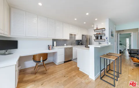 a kitchen with a sink a cabinets and chairs