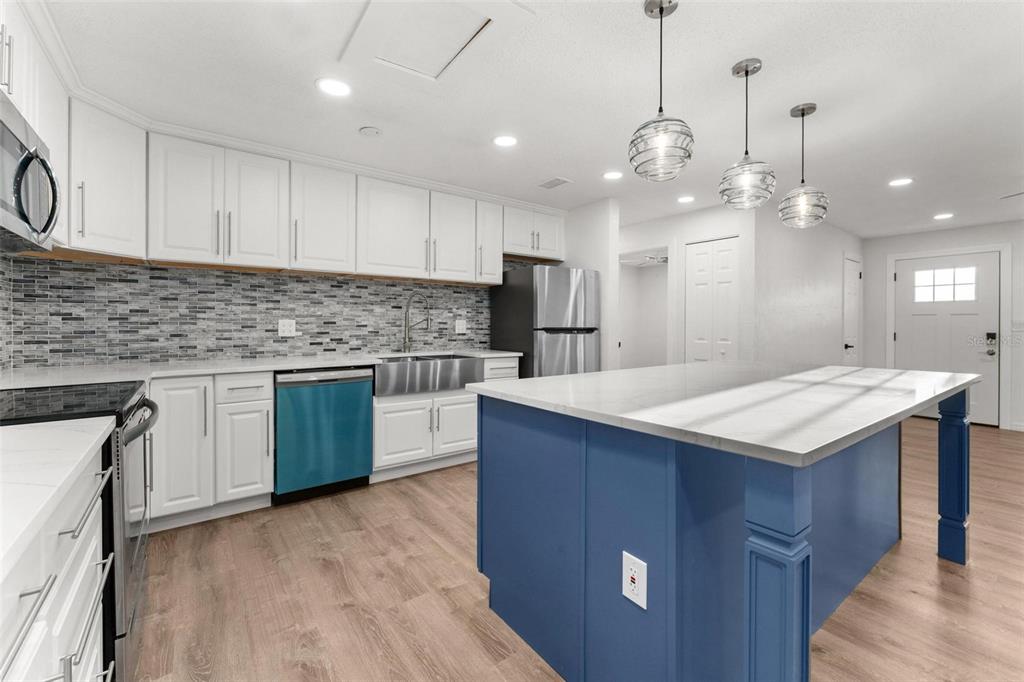 2203 Nottingham Road South Daytona, FL 32119 - Photo 11 of 40 a kitchen with kitchen island a sink stainless steel appliances and cabinets