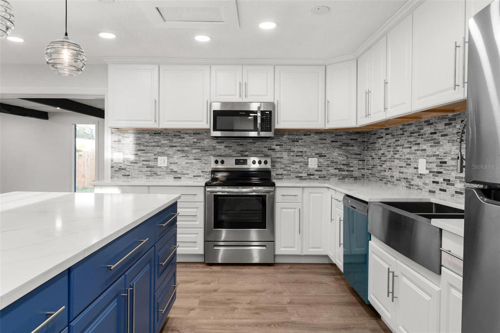 2203 Nottingham Road South Daytona, FL 32119 - Photo 14 of 40 a kitchen with granite countertop a stove a sink and a microwave