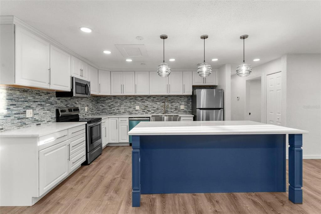 2203 Nottingham Road South Daytona, FL 32119 - Photo 8 of 40 a kitchen with kitchen island granite countertop a sink cabinets and stainless steel appliances