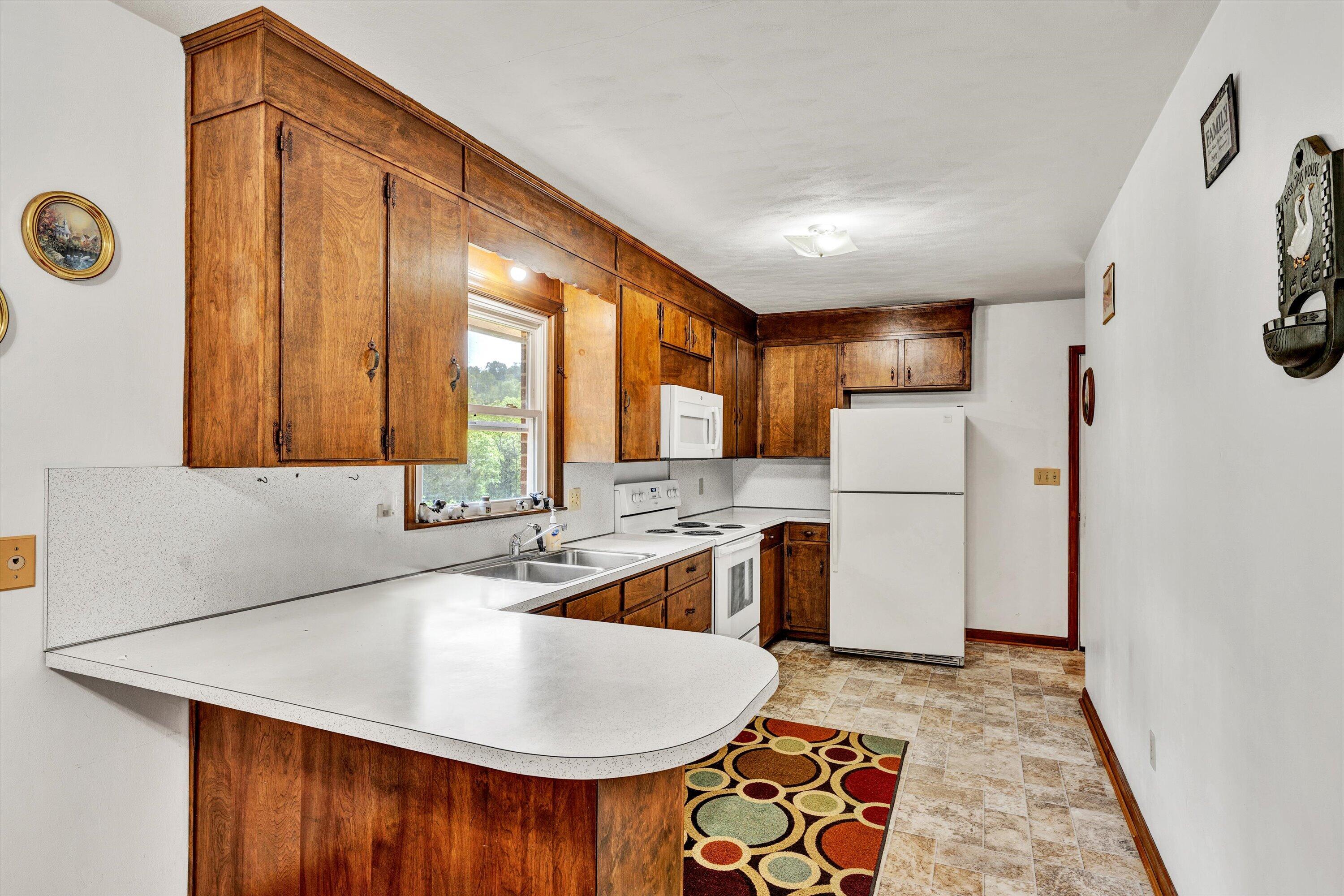 2296 Sandy Level Road Goodview, VA 24095 - Photo 13 of 48 a kitchen with a sink a refrigerator and a stove