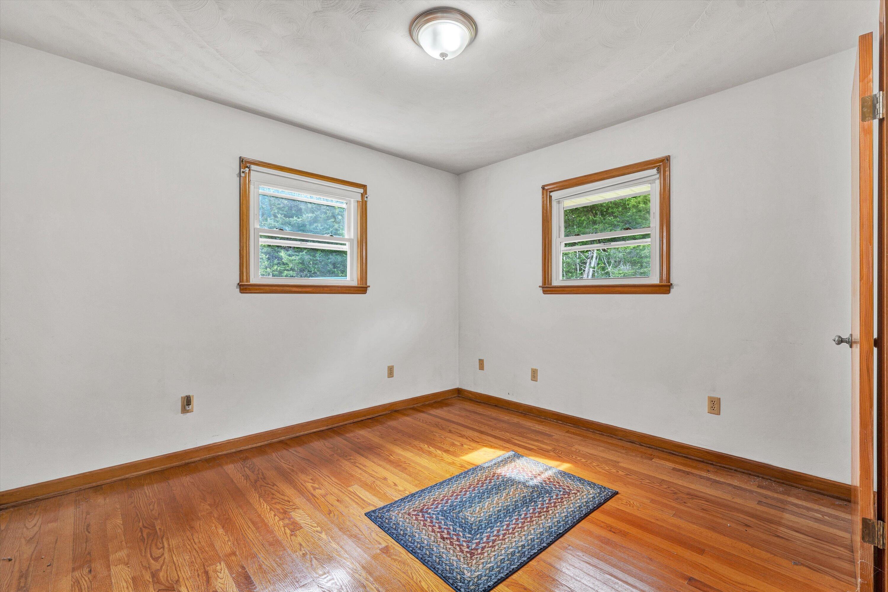 2296 Sandy Level Road Goodview, VA 24095 - Photo 20 of 48 a view of empty room with wooden floor and fan