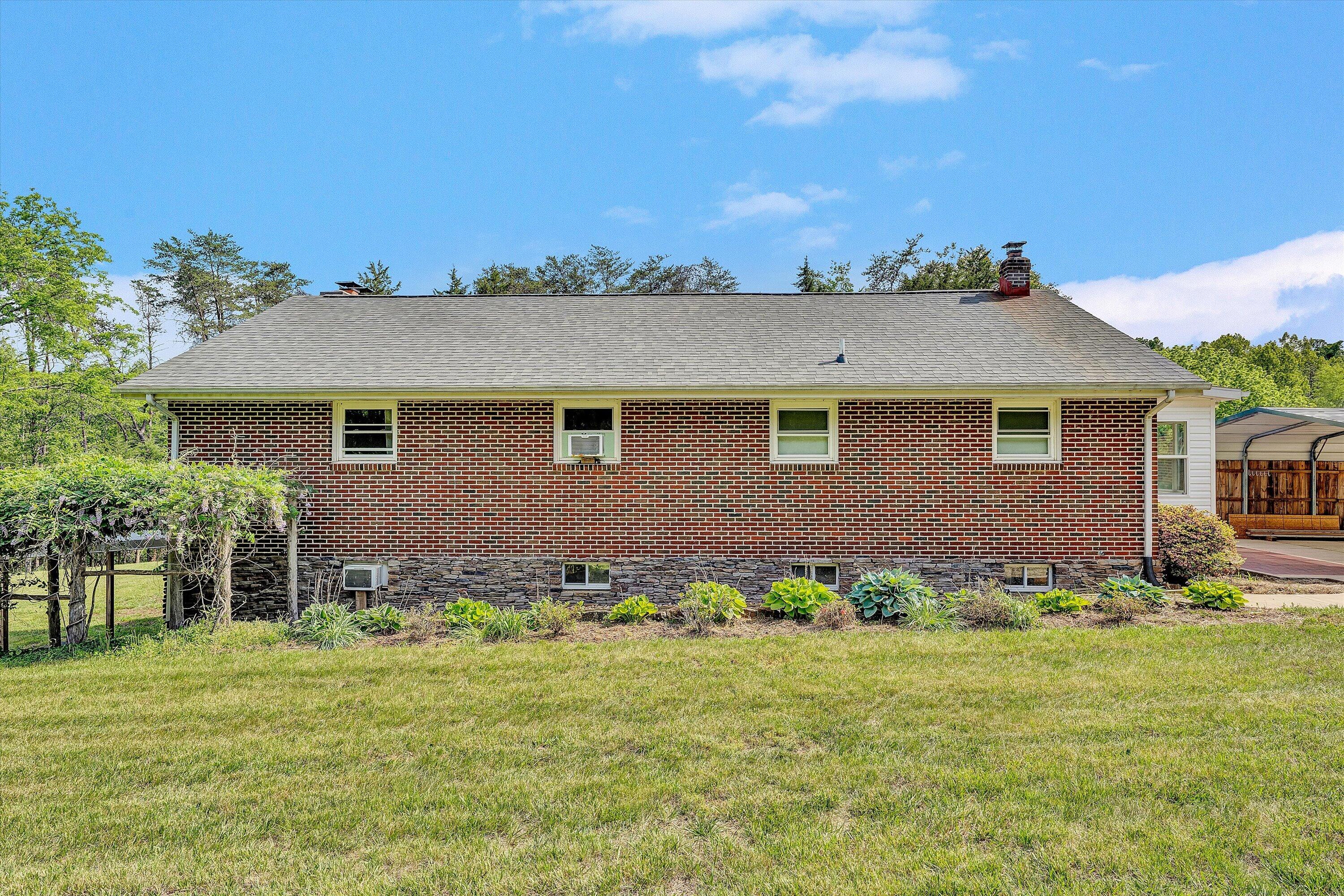 2296 Sandy Level Road Goodview, VA 24095 - Photo 32 of 48 a front view of a house with a garden