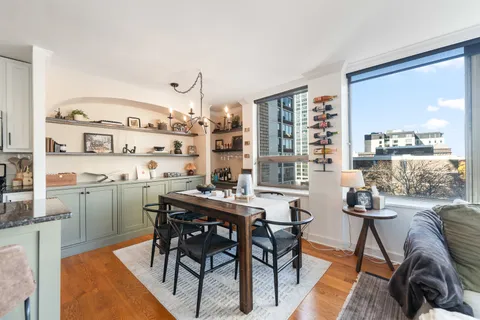 a dining room with furniture and a floor to ceiling window