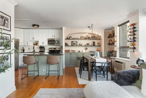 a kitchen with stainless steel appliances kitchen island granite countertop a table chairs sink and cabinets