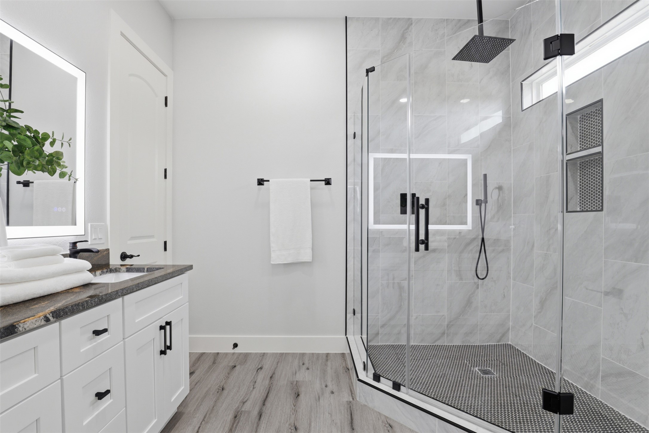 113 Los Robles Road Elgin, TX 78621 - Photo 12 of 20 Bathroom featuring a frameless glass shower enclosure with matte black hardware, dual shower niches, and a rainfall showerhead