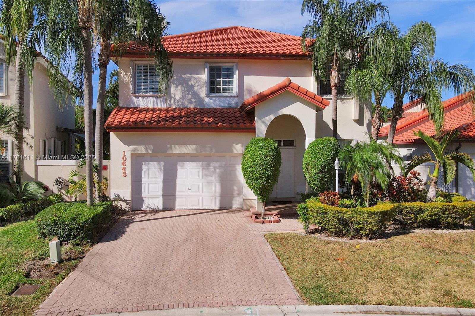 10643 Northwest 54th Street Doral, FL 33178 - Photo 1 of 27 a front view of a house with garden