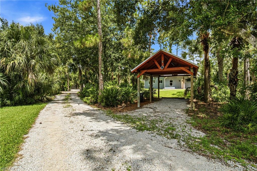 2053 17th Street Southwest Naples, FL 34117 - Photo 25 of 47 a view of a patio with a table and chairs under an umbrella