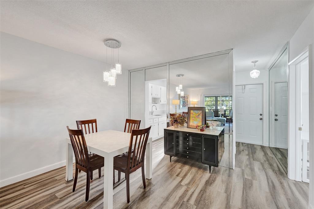 2751 East Golf Boulevard, Unit 2019 Pompano Beach, FL 33064 - Photo 24 of 68 a view of a dining room with furniture and wooden floor