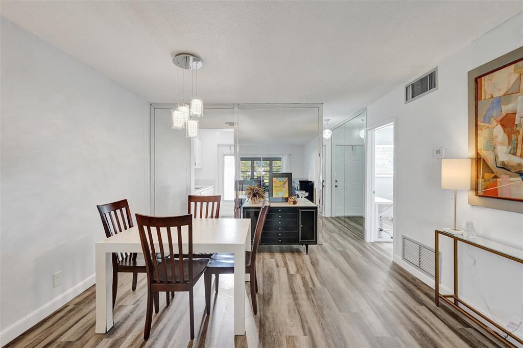 2751 East Golf Boulevard, Unit 2019 Pompano Beach, FL 33064 - Photo 25 of 68 a view of a dining room with furniture window and wooden floor