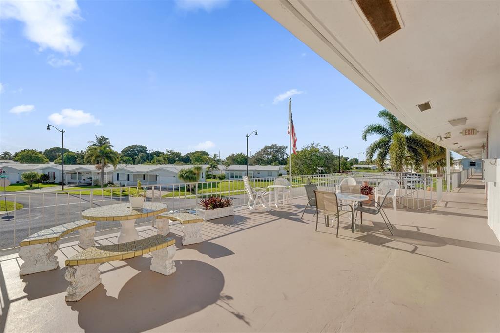 2751 East Golf Boulevard, Unit 2019 Pompano Beach, FL 33064 - Photo 43 of 68 a view of a patio with a table and chairs