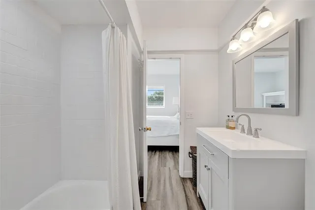 a bathroom with a tub shower vanity and a sink