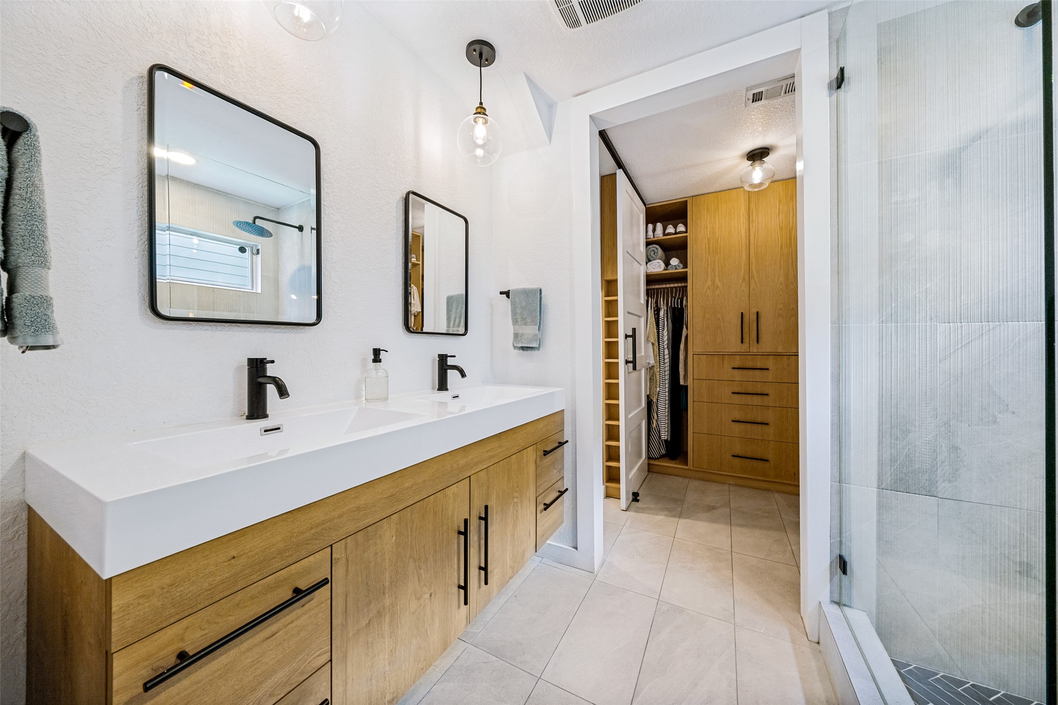 9205 Rowlands Sayle Road Austin, TX 78744 - Photo 17 of 25 A well-appointed bathroom features a double vanity and an adjoining organized walk-in closet.