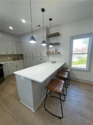 a kitchen with kitchen island a stove a table a sink and chairs