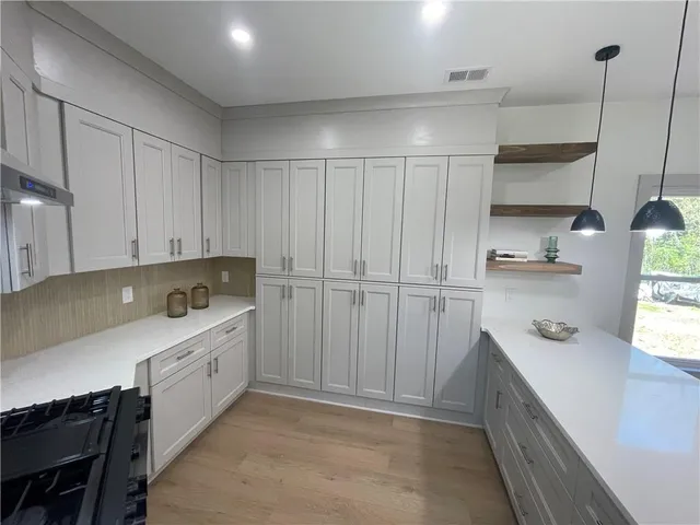 a kitchen with white cabinets and sink