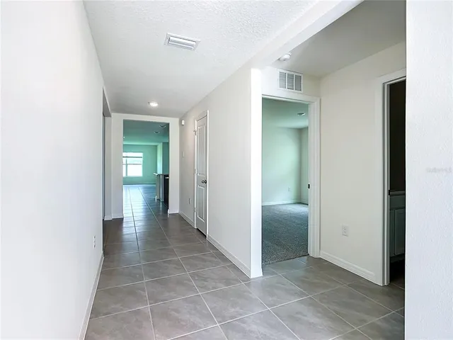 a view of hallway with a bathroom and a sink