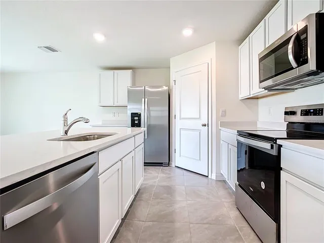a kitchen with stainless steel appliances granite countertop a refrigerator stove and sink