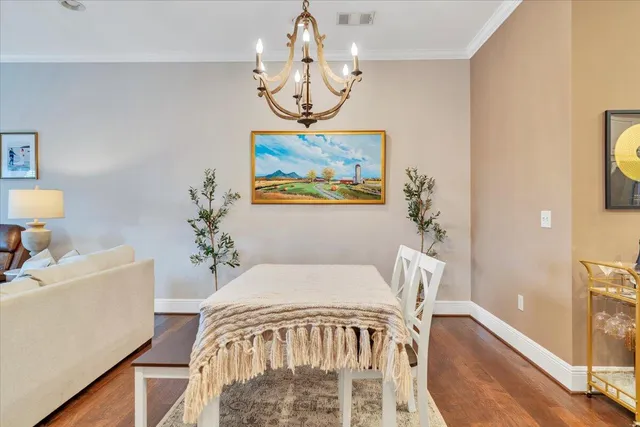 a view of a dining room with furniture a chandelier and wooden floor