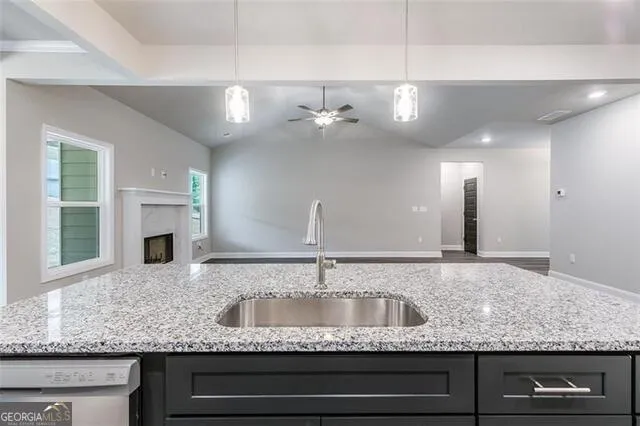 a kitchen with granite countertop a sink and stainless steel appliances