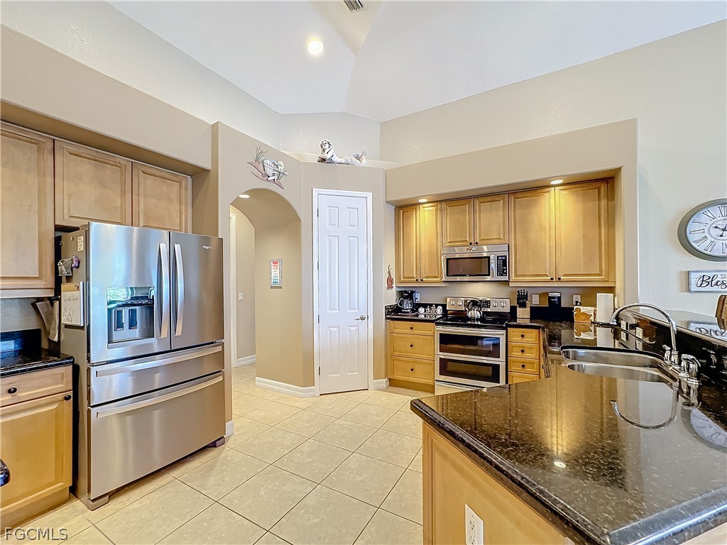 2115 Old Burnt Store Road North Cape Coral, FL 33993 - Photo 10 of 33 a kitchen with stainless steel appliances granite countertop a sink a stove and refrigerator