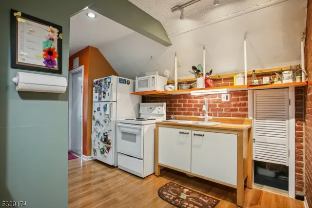 a view of kitchen with stainless steel appliances granite countertop a stove and a microwave