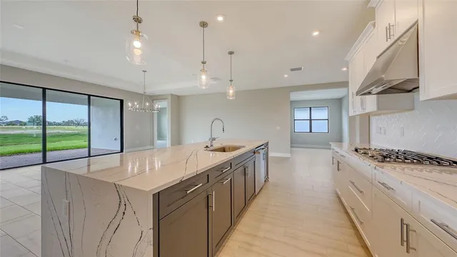 a large kitchen with kitchen island a large counter space a sink appliances and cabinets