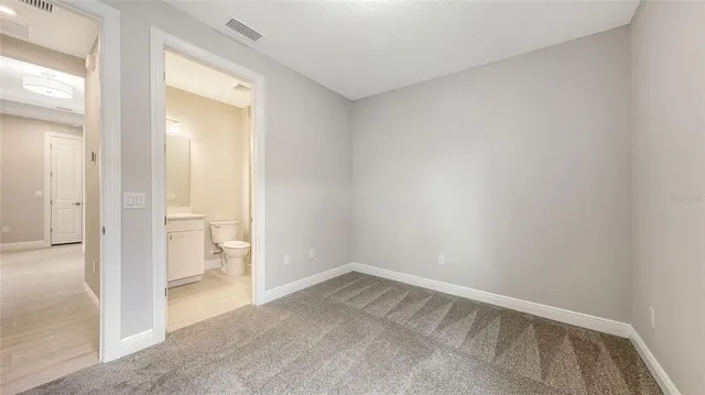 an empty room and a bathroom with a sink