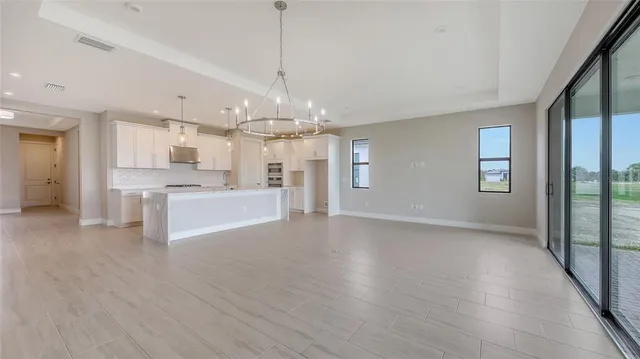 a view of a big room with wooden floor windows and a kitchen