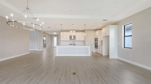 a view of a kitchen with wooden floor and a window