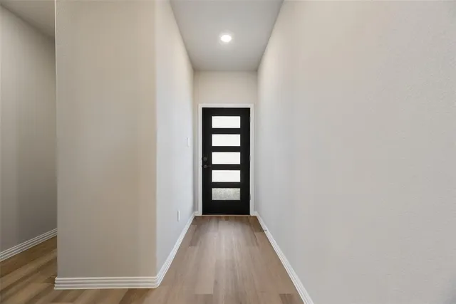 a view of a hallway with wooden floor and staircase