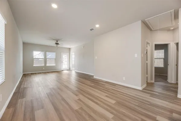 an empty room with wooden floor and windows