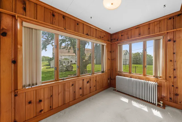 a spacious bedroom with a bed and a dresser next to a window