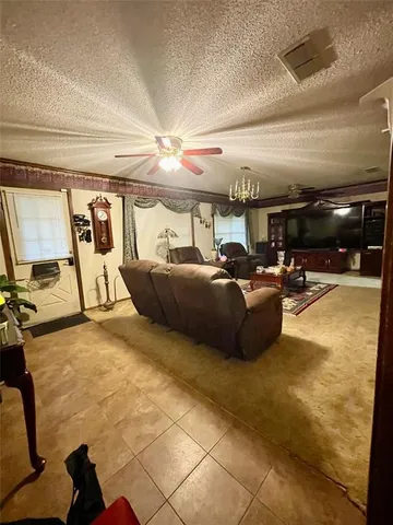 a living room with furniture a tv and lots of windows
