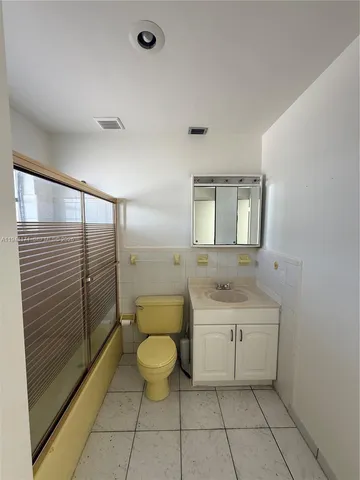 a spacious bathroom with a granite countertop sink a toilet and mirror