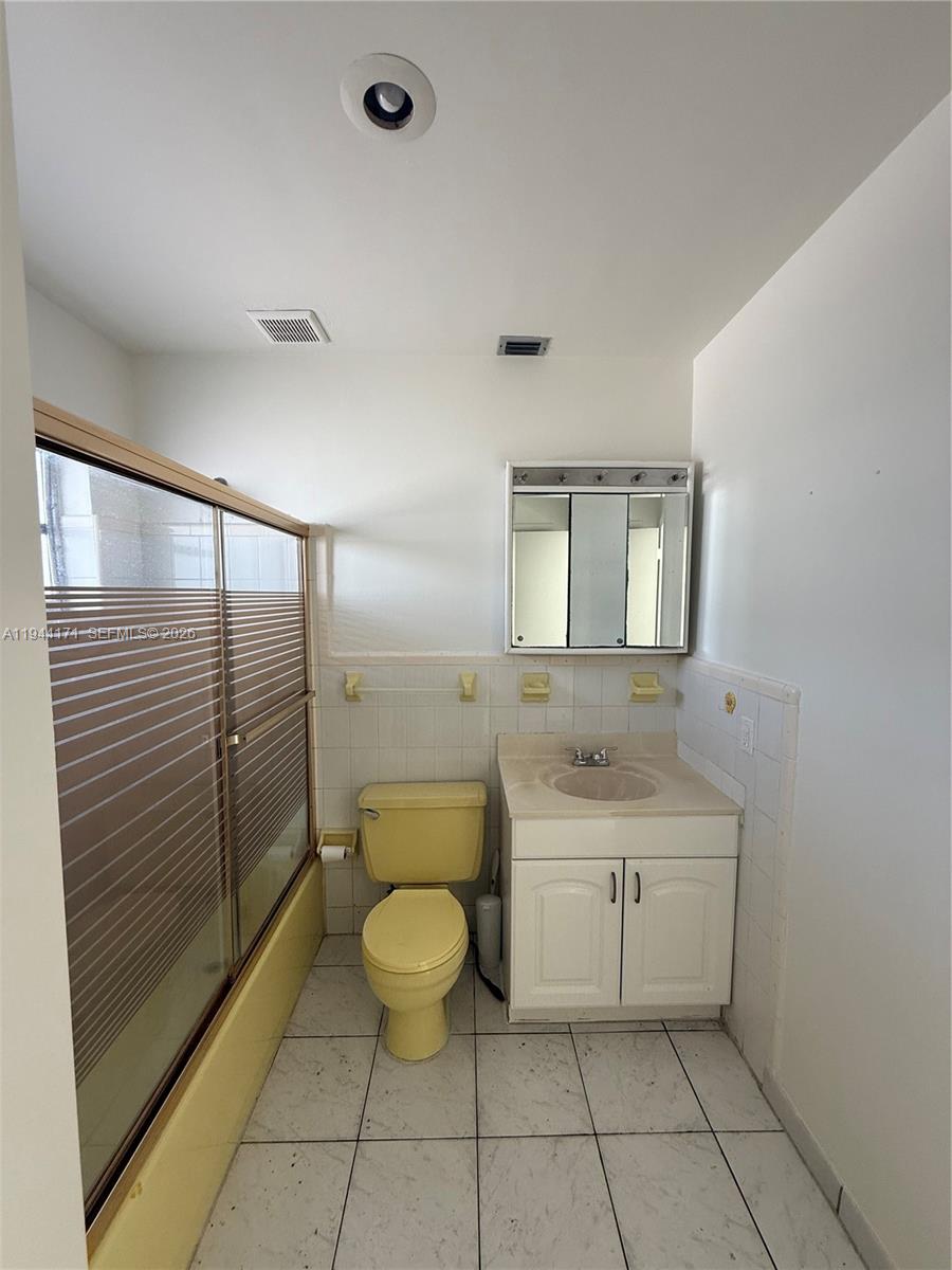 22 Southwest 55th Avenue Road, Unit U Miami, FL 33134 - Photo 4 of 6 a spacious bathroom with a granite countertop sink a toilet and mirror