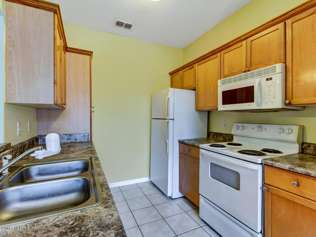 10961 Burnt Mill Road, Unit 1414 Jacksonville, FL 32256 - Photo 12 of 39 a kitchen with stainless steel appliances granite countertop a stove a sink and a microwave