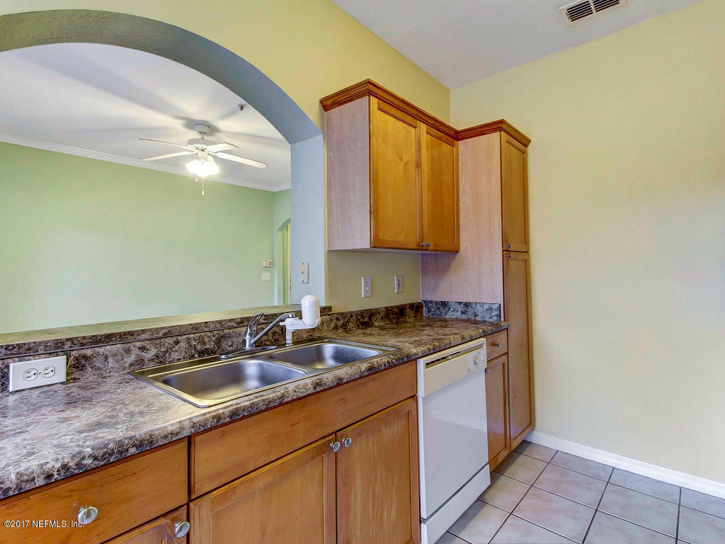10961 Burnt Mill Road, Unit 1414 Jacksonville, FL 32256 - Photo 13 of 39 a kitchen with granite countertop a sink a stove and cabinets