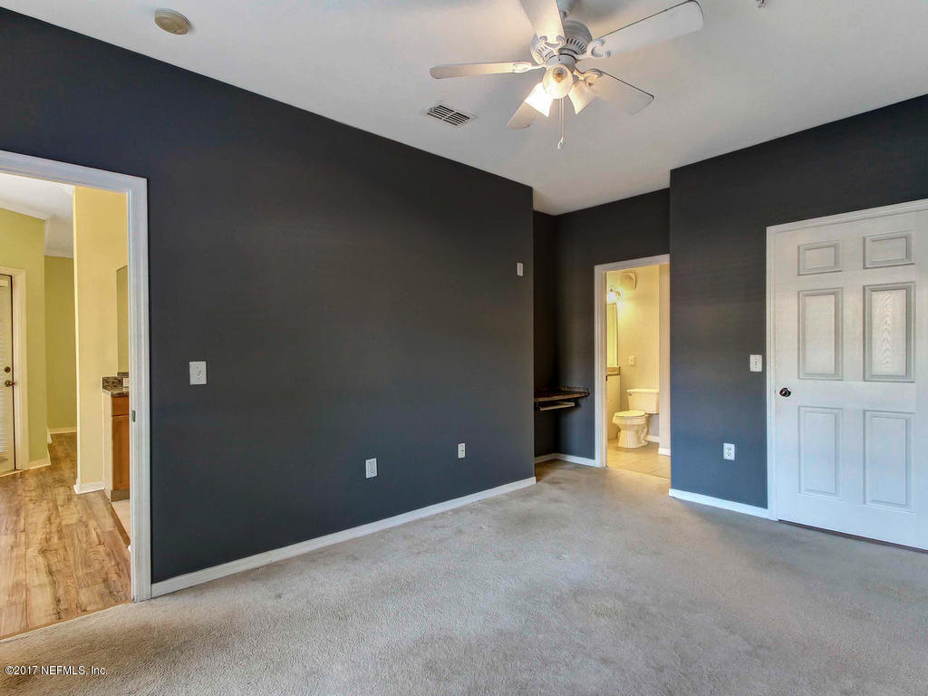 10961 Burnt Mill Road, Unit 1414 Jacksonville, FL 32256 - Photo 19 of 39 an empty room with closet and a chandelier fan