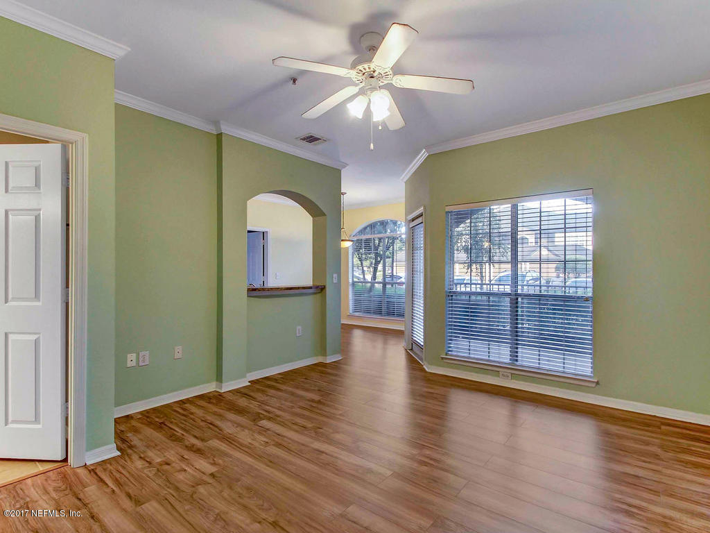 10961 Burnt Mill Road, Unit 1414 Jacksonville, FL 32256 - Photo 6 of 39 a bedroom with a large bed chandelier and a window
