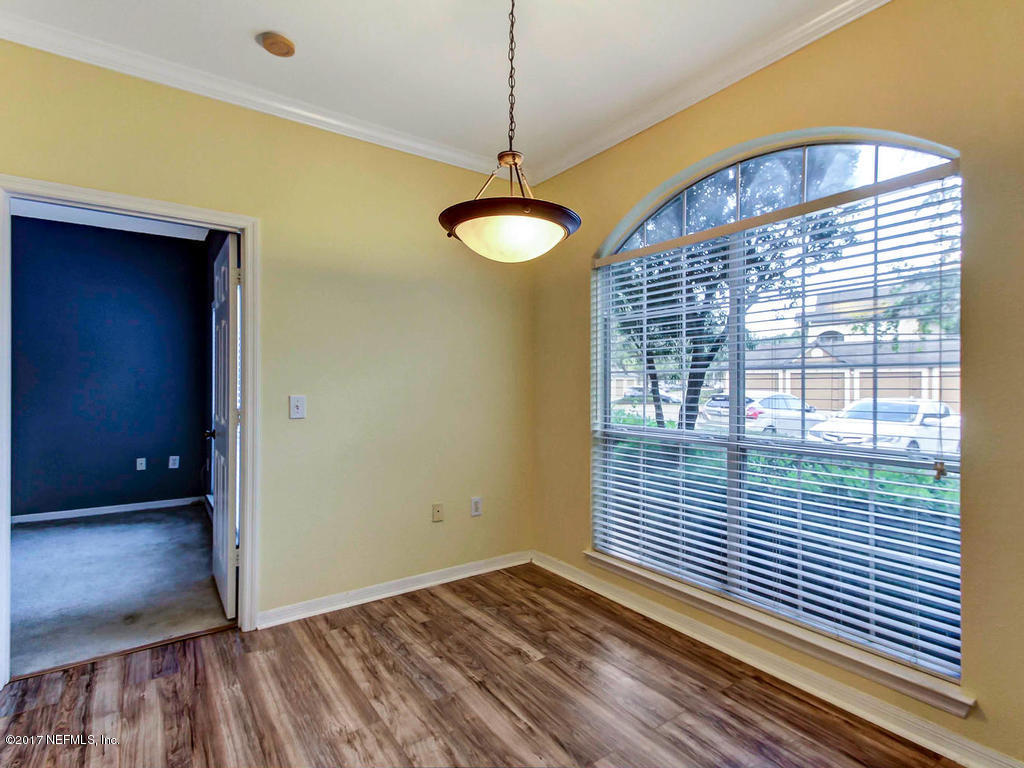 10961 Burnt Mill Road, Unit 1414 Jacksonville, FL 32256 - Photo 10 of 39 a view of an empty room with a window and wooden floor
