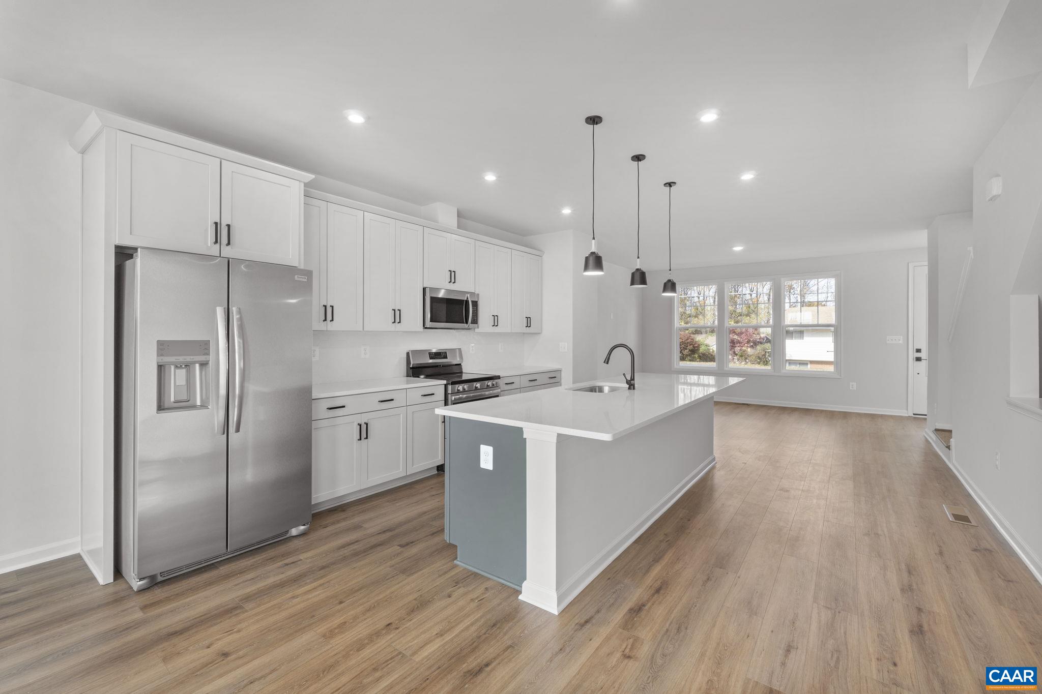 2209 Woodburn Road Charlottesville, VA 22901 - Photo 17 of 41 a large kitchen with a center island wooden floor stainless steel appliances and windows