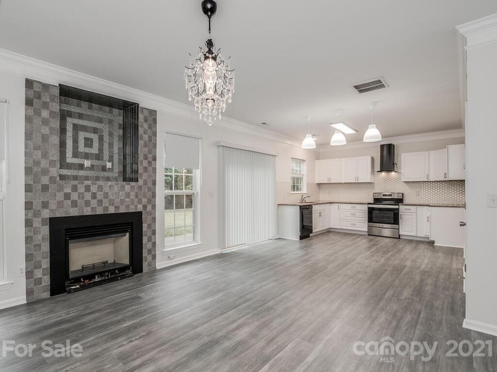 1108 Hannah Rae Court Charlotte, NC 28214 - Photo 6 of 16 a view of a kitchen with a sink wooden cabinets and fire place