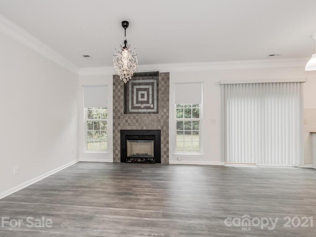 1108 Hannah Rae Court Charlotte, NC 28214 - Photo 7 of 16 a view of an empty room with wooden floor fireplace and a window