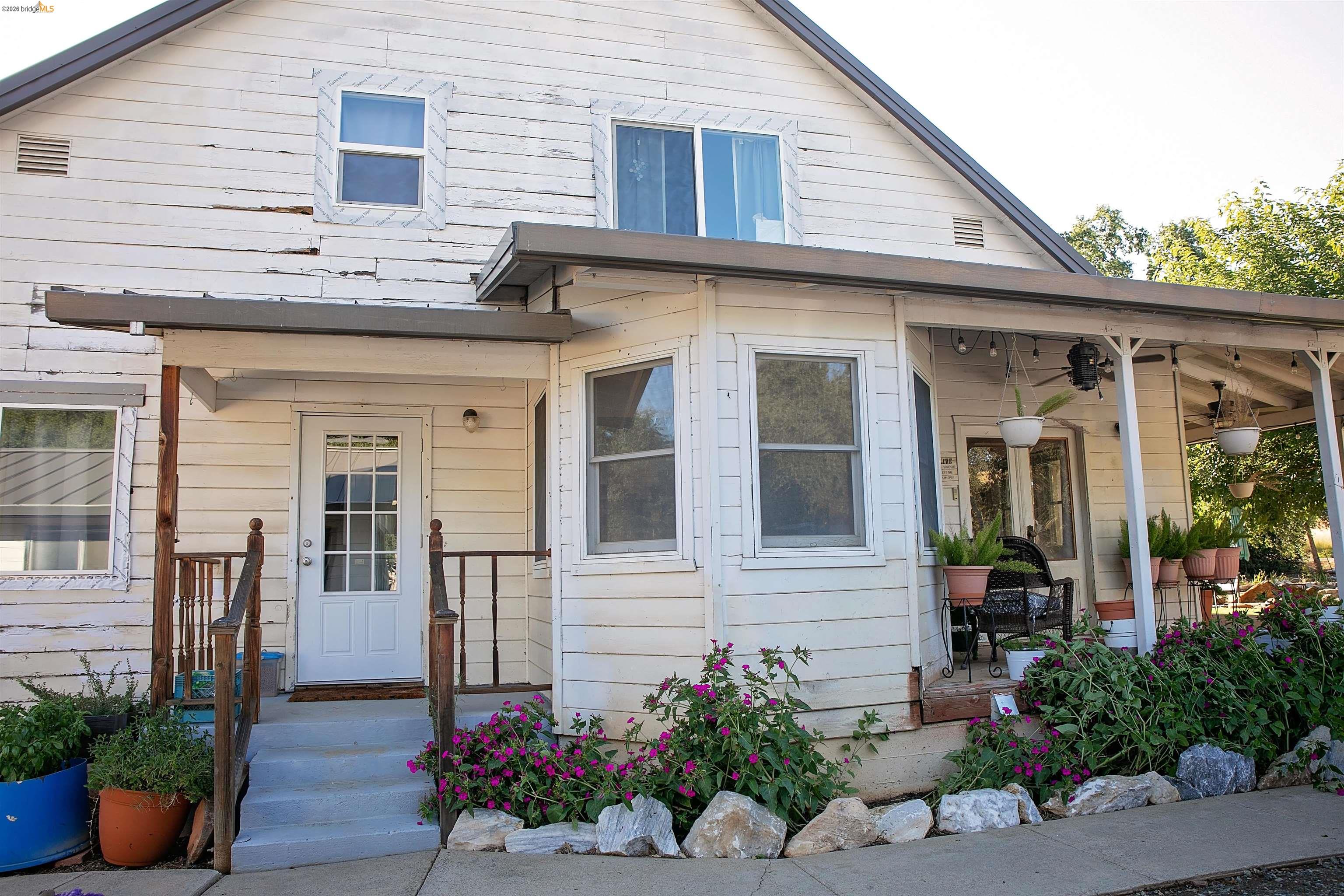 20982 Shaws Flat Road Sonora, CA 95370 - Photo 26 of 26 Exterior featuring a covered porch, multiple windows, and a partially enclosed side patio