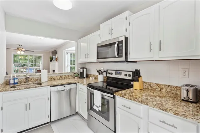 a kitchen with a refrigerator a stove top oven cabinets and a window