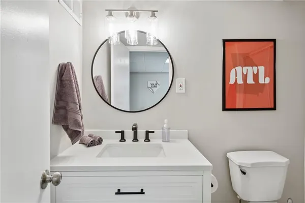 a bathroom with a toilet a sink and a mirror