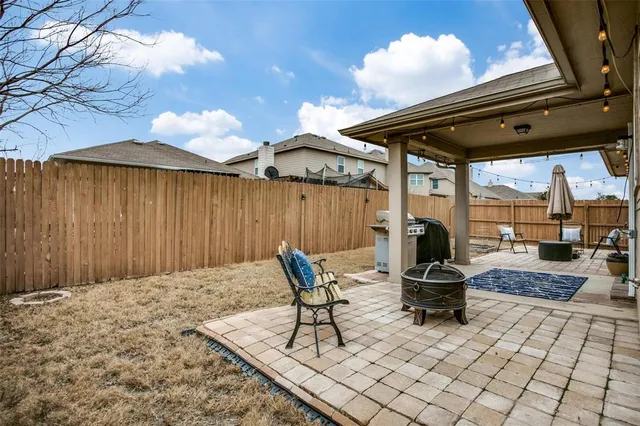 a backyard of a house with barbeque oven table and chairs