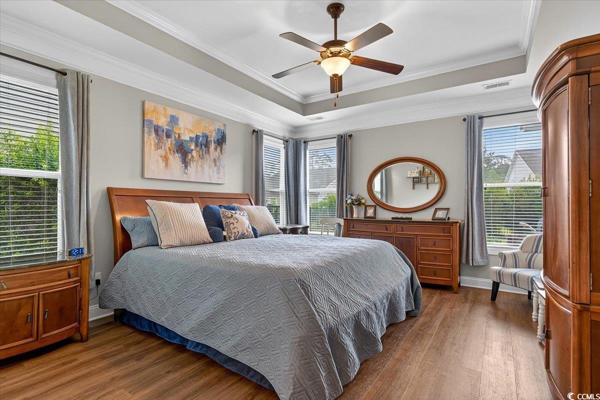 1719 Maplecress Way Myrtle Beach, SC 29577 - Photo 17 of 40 Bedroom featuring wood finished floors, multiple windows, a raised ceiling, ornamental molding, and a ceiling fan