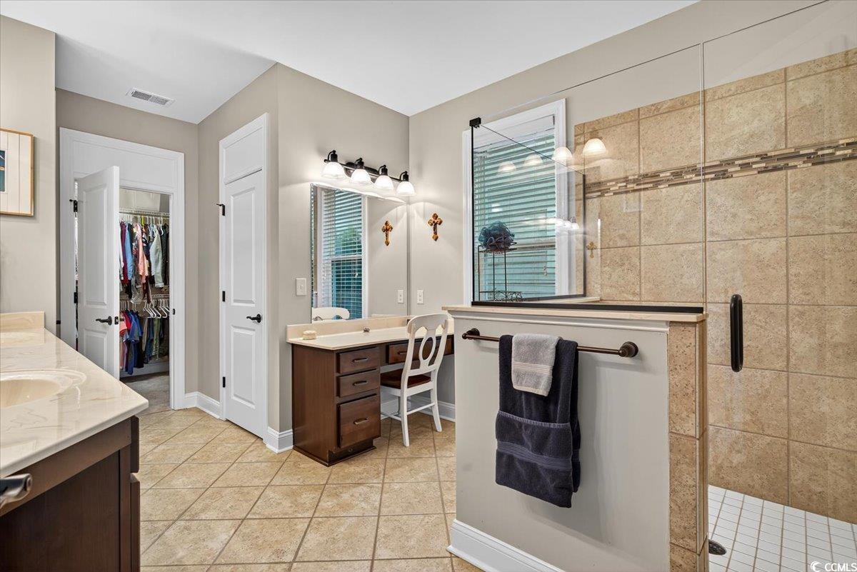 1719 Maplecress Way Myrtle Beach, SC 29577 - Photo 19 of 40 Bathroom featuring two vanities, a shower stall, tile patterned flooring, and a walk in closet