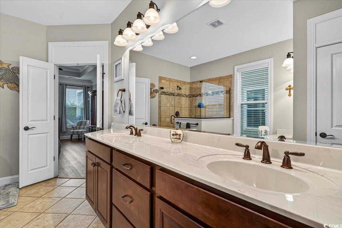 1719 Maplecress Way Myrtle Beach, SC 29577 - Photo 21 of 40 Bathroom featuring double vanity, tiled shower, and tile patterned flooring